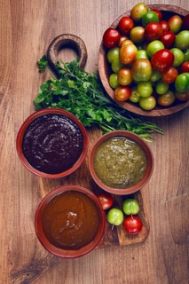 Set of tkemali sauces, three types of tkemali sauce, in ceramic bowls, top view, Georgian cuisine,