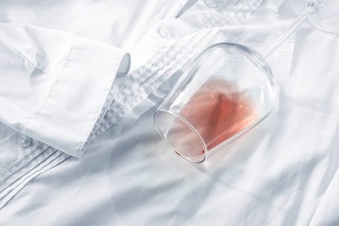 Glass, with pink wine, spilled on a white shirt, close-up, selective focus, no people, concept, top