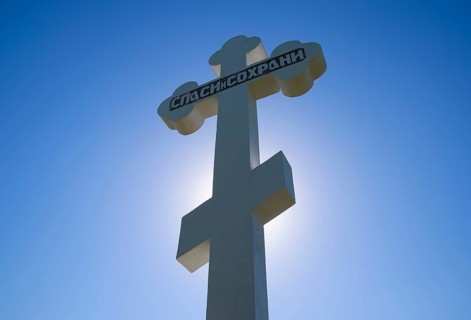 Orthodox cross against the blue sky and the sun. Krasnodar, Russia