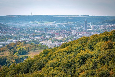 View of Jena city centre with the Jentower skyscraper, surrounded by forests and mountains, Jena,