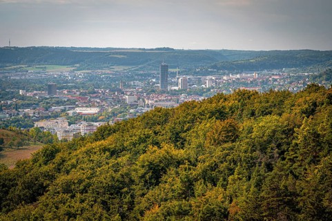Jena city centre with a striking high-rise building Jentower, surrounded by forests under a grey