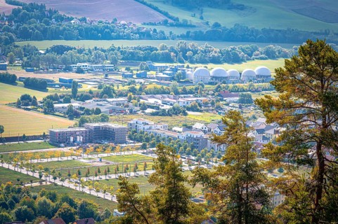 View of the residential area at Ölste with industrial buildings and trees in the foreground, Jena,