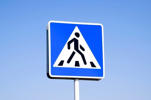 A pedestrian crossing sign. Sign on a blue sky background. Krasnodar, Russia