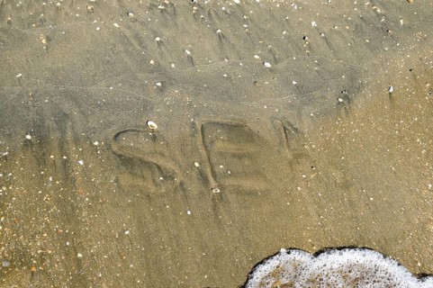 The inscription of the sea on the sand. Coastal sand and waves. Taman, Krasnodar Krai, Russia
