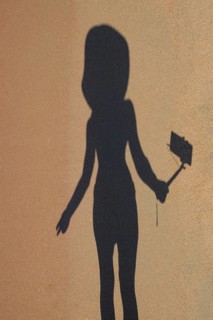 Shadow of a girl with a selfie stick on the beach. Golubitskaya, Russia