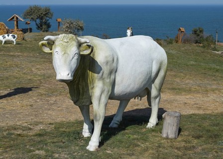 Dummy cow. white toy cow with a bell. Taman, Krasnodar Krai, Russia