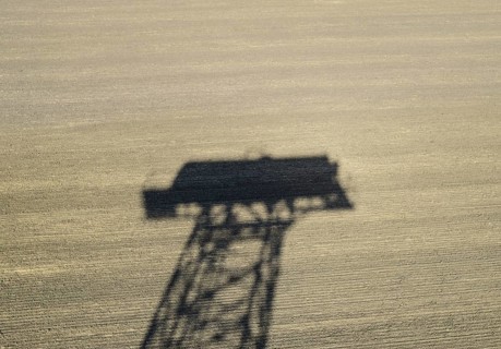 The shadow of a water tower on a plowed field. Atyrau, Kazakhstan