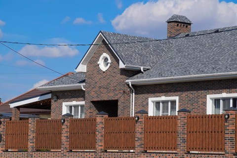 Asphalt shingle. Decorative bitumen shingles on the roof of a brick house. Atyrau, Kazakhstan