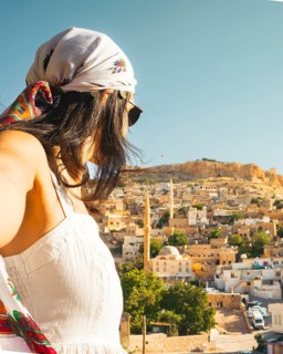 Traveler woman in white dress arms taking selfie self-portrait ooking over panoramic view of