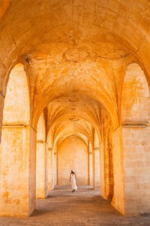 Kasimiye Medrese stone arches with traveler in white dress, iconic historic landmark in Mardin,