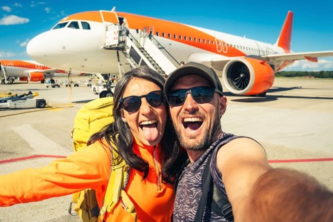 Young happy caucasian couple taking selfie portrait on departure or arrival destination for