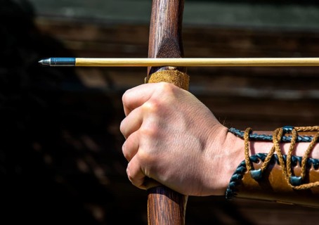 Hand Of An Archer Holds Bow And Arrow To Aim At Target, Austria