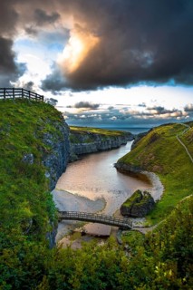Canyon And Entrance With Bridge To Smoo Cave And Atlantic Coast At Sunset Near Durness In Scotland,