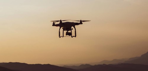 Quadcopter in the air with mountains landscape in a countryside of Slovenia