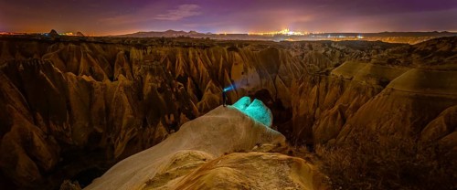 Cappadocia rose valley with male person at night posing. Turkey