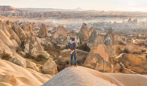 Male person with morning view of Goreme town in Cappadocia. Turkey travel