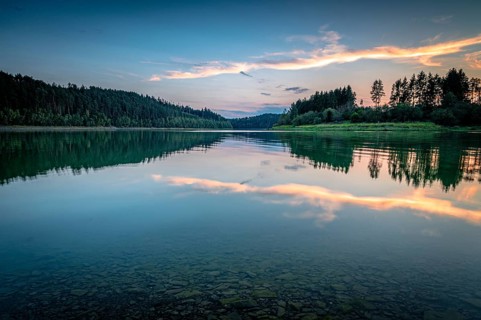 Reflection of clouds and trees in the water at sunset in a calm atmosphere, Zeulenrodaer Meer