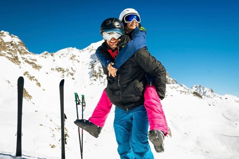 Happy young caucasian adult skiers couple in love having fun together playing enjoy leisure