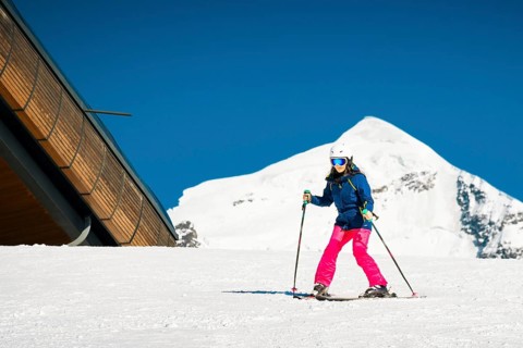 Young caucasian woman beginner skier on slope learn enjoy ski downhill in beautiful sunny day with