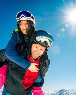 Happy young caucasian adult skiers couple in love having fun together playing enjoy leisure