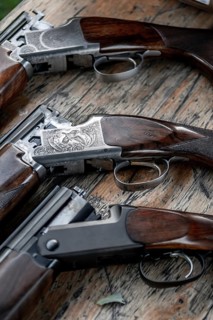 Details Of Open Hunting Rifles Laying On Wooden Table