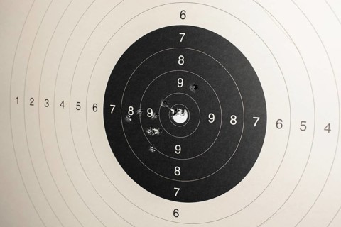 Hitmarks And Spot-On Hit On Round Paper Target With Bullet Holes From Shooting Training