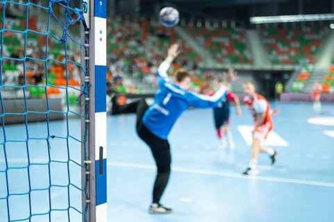 Detail of handball goal post with net and handball match in the background. handball. Lubin, Poland