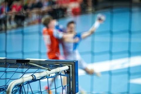 Detail of the handball goal and blurred players in action in the background. Lubin, Poland