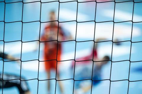 The net behind the goal and silhouette of handball players in the background. Lubin, Poland