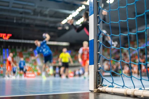 Detail of handball goal post with net and handball match in the background. handball match. Lubin,