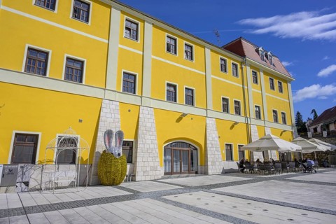 Square in front of old house with café and glittering Easter bunny figure, Varaždinske toplice,