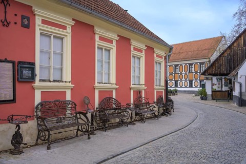 Alley in the old town centre with wrought-iron benches made from old metal parts, Varaždin,