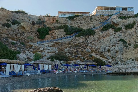 Secluded Grande Blue Beach with blue parasols and clear sea water, Grande Blue Beach, Stegna,