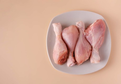 Chicken legs on a plate ready for cooking broth, copy space