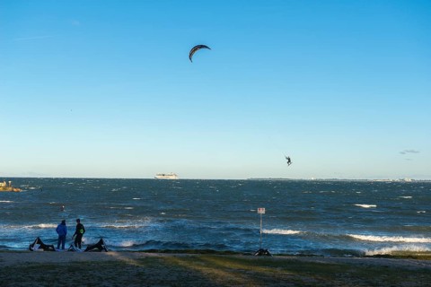 Kitesurfing in the Bay of Kiel in strong winds, high swell, Big Air Jump, Strande near Kiel,
