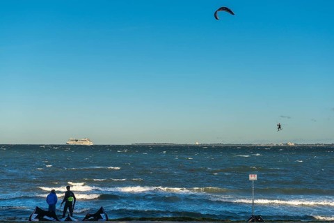 Kitesurfing in the Bay of Kiel in strong winds, high swell, Big Air Jump, Strande near Kiel,