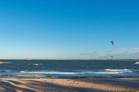 Kitesurfing in the Bay of Kiel in strong winds, high swell, Big Air Jump, Strande near Kiel,