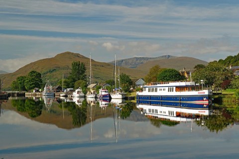 Harbour with boats and reflections under the surrounding green mountains, Caledonian Canal,