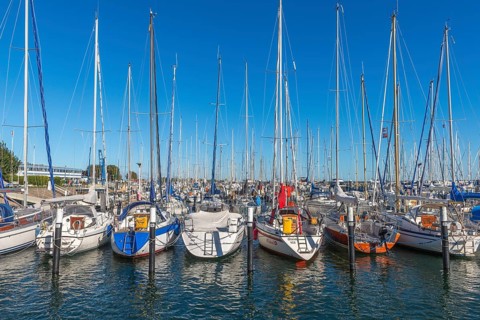Strande marina near Kiel, Rendsburg-Eckernförde district, ship masts, water reflection, dolphins,