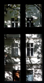 View through a window to an opposite facade of a multi-storey residential building with classical