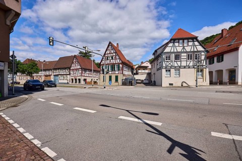 Half-timbered houses, pointed roof with red roof tiles, traffic lights, streets, vehicles, blue