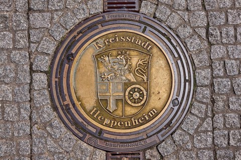 Manhole cover, district town of Heppenheim, golden, pavement made of paving stones, rain gutter,