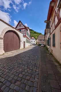 Old town, alley, historic half-timbered houses, wall, access gate, blue sky, cumulus clouds,