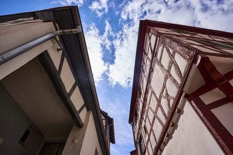 Old town, half-timbered houses, facade with downpipe, steep frog perspective, blue sky, cumulus