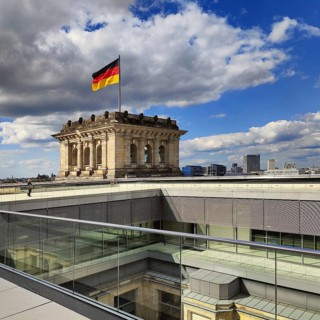 Viewing platform with a German flag in the wind on one of the corner towers of the Reichstag