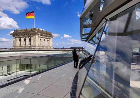 Viewing platform with a German flag in the wind on one of the corner towers and the Reichstag dome,