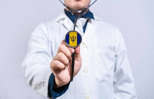 Doctor hands holding stethoscope with Barbados flag. Barbados health and care concept