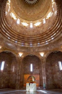 An interior with a domed golden dome and impressive pillars of light that create a majestic