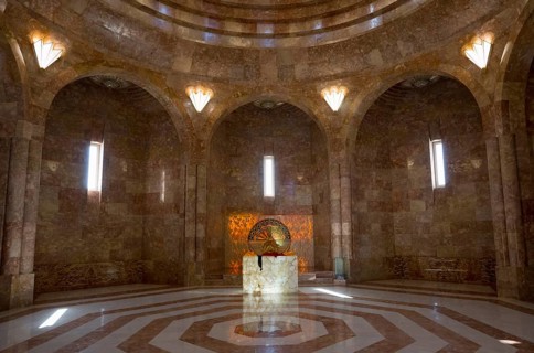An impressive hall with a vaulted ceiling and marble floor in golden tones, light floods in through