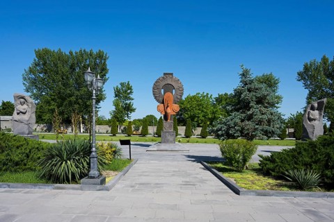 Park landscape with sculptures and plants under a blue sky, in the garden of the Yazidi Temple,